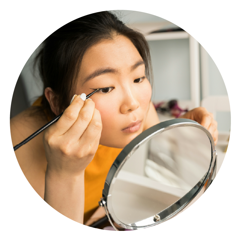 close up of a girl doing her eyeliner in a small desktop mirror to show how brands play a meaningful role in our lives