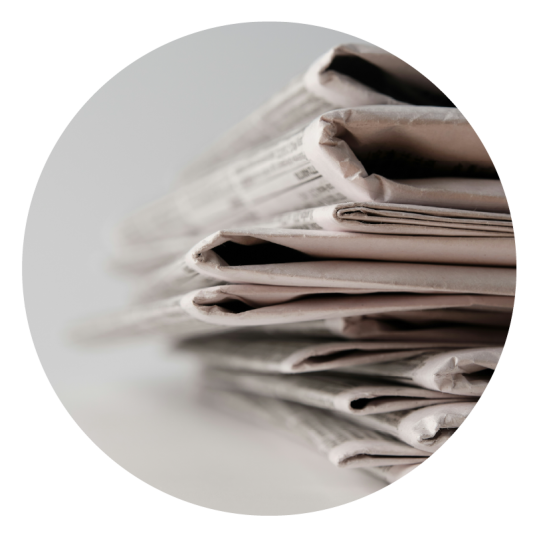 a close up of stack of old newspapers showing the most important news and not burying the lead