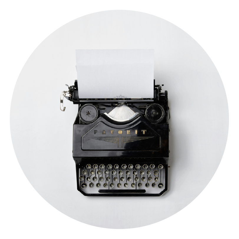 grey clean background with a black, old type writer showing storytelling through type